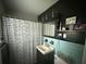 Bathroom with a black and white shower curtain, striking black walls, and blue tile at 1139 Belvedere Dr, Hanahan, SC 29410
