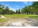 Overiew of a spacious, grassy backyard with a few storage sheds and mature trees at 122 Lawrence Rd, Moncks Corner, SC 29461