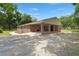 Brick home featuring a covered porch, driveway, and mature trees on a sunny day at 122 Lawrence Rd, Moncks Corner, SC 29461