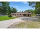 Charming brick ranch-style home with a covered carport and long driveway surrounded by mature trees and well maintained lawn at 122 Lawrence Rd, Moncks Corner, SC 29461