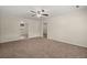 Well-lit living room featuring neutral carpeting, ceiling fan, paneled walls, and views into other areas of the house at 122 Lawrence Rd, Moncks Corner, SC 29461
