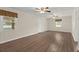 Open-concept living area with wood-look floors, paneled walls, windows with valances, and multiple ceiling fans at 122 Lawrence Rd, Moncks Corner, SC 29461