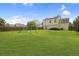 Spacious backyard with green grass, wooden fence, playset, and two-story house at 136 Blue Jasmine Ln, Summerville, SC 29483