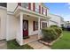 Inviting front porch with decorative door, white pillars, and landscaped greenery at 136 Blue Jasmine Ln, Summerville, SC 29483