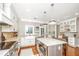 This kitchen features white cabinets, modern appliances, an island with a cooktop, and a wine cooler at 136 Fair Sailing Rd, Mount Pleasant, SC 29466