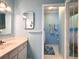 Bright bathroom with soft blue walls, vanity with sink and shower with ocean themed curtain at 14 Ashland Dr, Charleston, SC 29407
