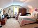 Upstairs bedroom features sloped ceilings, a comfortable bed and sitting area near the window at 14 Ashland Dr, Charleston, SC 29407
