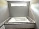 Close-up of a soaking tub in a bathroom with light gray walls and a small window at 144 Craft Ln, Round O, SC 29474