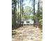 Charming single-story home with white siding and dark trim surrounded by tall trees at 144 Craft Ln, Round O, SC 29474