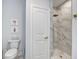Bathroom featuring a toilet and a doorless shower with marble tile and gold colored hardware at 16 Oakwood Ln, Edisto Island, SC 29438