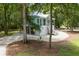 Exterior view of the elevated coastal home with light blue siding, a spacious gravel yard, and mature trees at 16 Oakwood Ln, Edisto Island, SC 29438