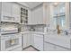 Bright kitchen featuring white cabinets, blue backsplash, stainless steel appliances and a farmhouse sink at 16 Oakwood Ln, Edisto Island, SC 29438