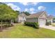 Backyard with a detached garage, green grass, and trimmed bushes on a partly cloudy day at 165 Village Ponds Dr, Summerville, SC 29483