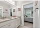 Bright bathroom with double sinks, granite counters and a view to the next room's bed at 165 Village Ponds Dr, Summerville, SC 29483
