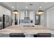 Modern kitchen with white cabinets, stainless steel appliances, and a stone-topped island under pendant lighting at 165 Village Ponds Dr, Summerville, SC 29483