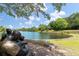 Scenic lakeside view with a bronze statue, lake, clear skies, and lush green vegetation at 165 Village Ponds Dr, Summerville, SC 29483