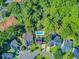 An aerial view shows a pool surrounded by lush greenery within a residential neighborhood at 180 Willowbend Ln, Summerville, SC 29485