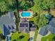 Aerial view showcasing a sparkling private pool with vibrant red umbrellas in a backyard oasis at 180 Willowbend Ln, Summerville, SC 29485