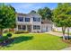 Beautiful two-story home with lush green lawn, black shutters, and a two-car garage surrounded by mature trees at 180 Willowbend Ln, Summerville, SC 29485