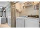 Functional laundry room with washer, dryer, shelving, and neutral colors, enhancing the home's practicality at 180 Willowbend Ln, Summerville, SC 29485