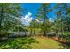 Well-manicured backyard with lush grass, mature trees, and scenic waterfront views at 1971 N North Creek Dr, Mount Pleasant, SC 29466