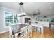 Light-filled dining area adjacent to kitchen featuring hardwood floors, large windows and stylish chandelier at 1971 N North Creek Dr, Mount Pleasant, SC 29466