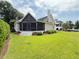 A shot of the backyard featuring the screened-in porch, green grass, and neatly trimmed bushes at 213 Ashmont Dr, Wando, SC 29492
