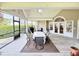 Screened-in porch area featuring a dining set, ceiling fan, and outdoor furniture for relaxing and entertaining at 213 Ashmont Dr, Wando, SC 29492