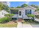 Charming home featuring a screened-in porch, complemented by a landscaped front yard and flowering plants at 2215 Suffolk St, North Charleston, SC 29405