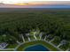Aerial view of neighborhood homes surrounding a pond, showcasing the community's layout and beautiful surroundings at 233 Camber Rd, Huger, SC 29450