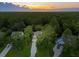 Aerial view of a property nestled among lush trees with a long driveway and well-manicured landscaping at 233 Camber Rd, Huger, SC 29450