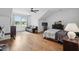 Large bedroom with hardwood floors, a window view, and an adjacent black leather sofa at 233 Camber Rd, Huger, SC 29450