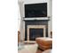 Cozy fireplace with brick surround and mantle below a large television in the main living area at 233 Camber Rd, Huger, SC 29450