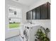 Bright laundry room with modern washer and dryer, ample storage cabinets, and a large window for natural light and convenience at 233 Camber Rd, Huger, SC 29450