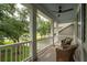 Inviting front porch with wicker chairs, white railings, and serene views of the water at 233 Camber Rd, Huger, SC 29450
