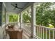 Inviting porch with wicker chairs, white railings, and serene views of lush greenery at 233 Camber Rd, Huger, SC 29450
