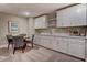 Finished basement bar area features white cabinetry, marble countertops, sink, and seating at 265 Huguenot Trl, Huger, SC 29450