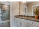 Well-lit bathroom featuring gray quartz countertops, white cabinets, and a seamless glass shower at 265 Huguenot Trl, Huger, SC 29450