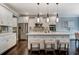 Spacious kitchen features white cabinets, stainless steel appliances, pendant lights, and a center island with seating at 265 Huguenot Trl, Huger, SC 29450