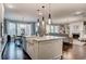 Bright open kitchen features island with sink, stainless appliances, and a view into a spacious living room at 265 Huguenot Trl, Huger, SC 29450