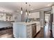 Bright kitchen island with white cabinets, pendant lighting, stainless steel appliances, and a view into the living room at 265 Huguenot Trl, Huger, SC 29450