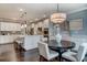 Bright kitchen features white cabinets, large island with seating, pendant lighting, and a round dining table at 265 Huguenot Trl, Huger, SC 29450