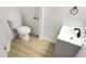 This bathroom showcases a toilet and a gray vanity, complemented by light wood-look flooring at 3013 Argyll Dr, Summerville, SC 29483
