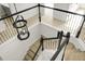 View of a staircase with white railings, black banisters and light wood stairs with a decorative light fixture at 3013 Argyll Dr, Summerville, SC 29483