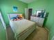 Green bedroom with a bed adorned by various plush toys, a dresser, and carpeted floors at 309 Hathaway Dr, Goose Creek, SC 29445