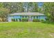 Charming blue home featuring a well-manicured lawn and attached garage in a lush green neighborhood at 312 Woodward Blvd, Summerville, SC 29483