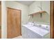 A utility room showcases a washer, dryer, shelving, and a door leading to a storage space at 312 Woodward Blvd, Summerville, SC 29483