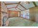 Bright living room featuring exposed beams, wood paneling, a brick fireplace, and access to other living spaces at 312 Woodward Blvd, Summerville, SC 29483
