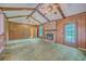 Spacious living room featuring wood paneling, a brick fireplace, exposed beams, and a ceiling fan at 312 Woodward Blvd, Summerville, SC 29483