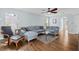 Inviting living room with hardwood floors, gray sectional sofa, and open view to an adjacent dining room at 340 Stefan Dr, Charleston, SC 29412